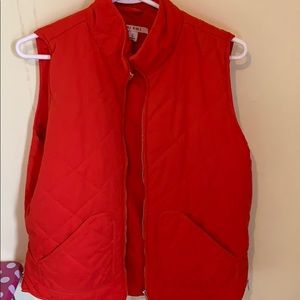 Orange vest with gold zippers.